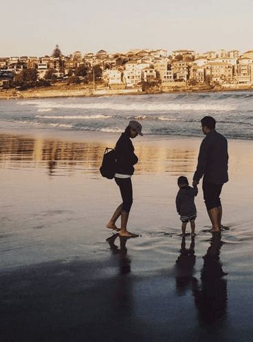 A family walking together along a beach at sunset