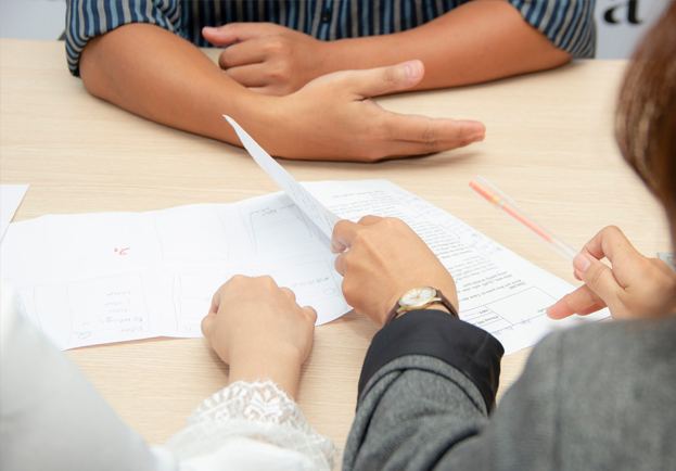 Hands reviewing and signing a legal document at a desk